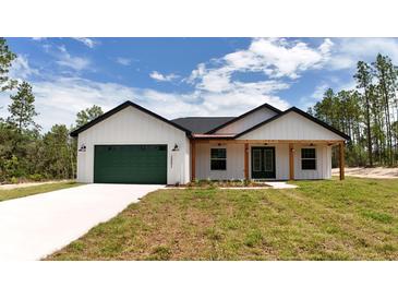 Beautiful single story house with a green garage door and wood-accented porch at 12251 Sw 67Th Ln, Ocala, FL 34481