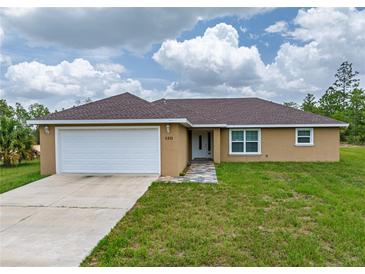 Inviting single story home featuring a two-car garage, neutral stucco, and a well-manicured lawn at 5331 Sw 121St Ter, Ocala, FL 34481