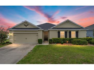 Charming single-story home featuring a well-maintained lawn, two-car garage, and a welcoming front entrance beneath a colorful sky at 6646 Sw 64Th Ave, Ocala, FL 34476