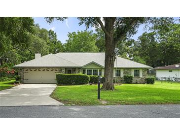 Charming single-story home featuring a well-maintained front yard and an attached two-car garage at 8205 Sw 100Th Lane Rd, Ocala, FL 34481