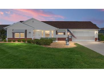Charming home featuring a well-manicured lawn, attractive landscaping, and an inviting front porch at 8554 Sw 63Rd Ct, Ocala, FL 34476