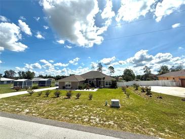 Landscaped front yard featuring green grass, white rock beds, and lovely shrubs adding to the home's curb appeal at 10405 Sw 47Th Ave, Ocala, Florida, FL 34476