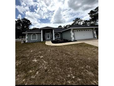 Charming single-story home with a well-manicured lawn and a two-car garage at 2550 Sw Ivy Pl, Dunnellon, FL 34431