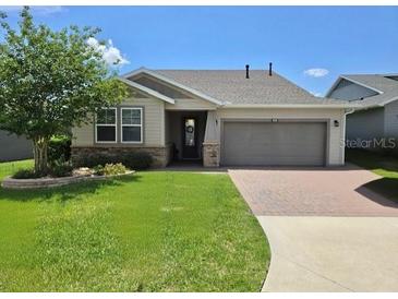 Well-maintained single-story home with a manicured lawn, two-car garage, and a welcoming front entrance at 4232 Nw 56Th Ct, Ocala, FL 34482