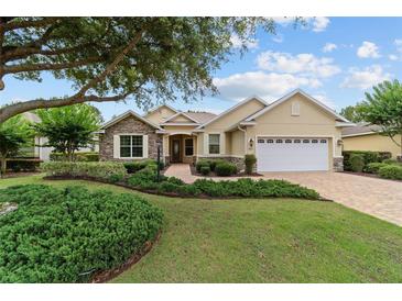 Charming single-story home with stone accents, lush landscaping, and a brick driveway at 8611 Sw 83Rd Loop, Ocala, FL 34481