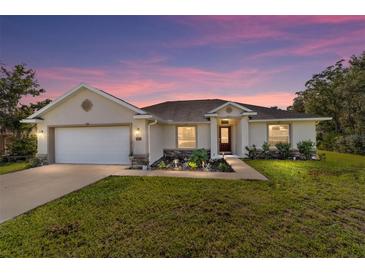 Charming single-story home with a well-manicured lawn and inviting curb appeal at dusk at 9957 Sw 45Th Ave, Ocala, FL 34476