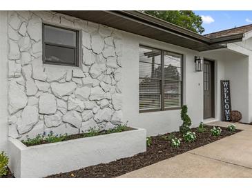 The exterior features a stone accent wall and a well-maintained lawn with decorative plants and flower beds at 21191 Sw Plantation St, Dunnellon, FL 34431