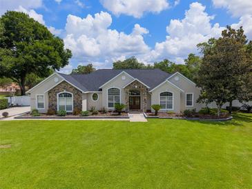 Charming single-story home with stone accents, arched windows, and a lush green lawn at 3883 Se 51St Ct, Ocala, FL 34480