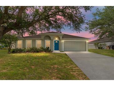 Charming single-story home with a well-manicured lawn, inviting blue door, and attached two-car garage at 4531 Se 27Th St, Ocala, FL 34480