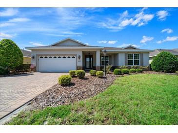 Charming single-story home featuring a well-manicured lawn and a brick-paved driveway at 8640 Sw 83Rd Loop, Ocala, FL 34481