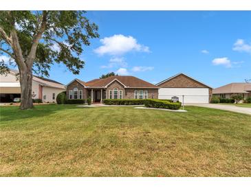 Charming brick home with manicured lawn and mature landscaping on a sunny day at 9641 Se 70Th Ter, Ocala, FL 34472