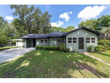 Charming single-story home featuring a well-manicured lawn, covered carport and a welcoming front entrance at 11430 Se 54Th Ave, Belleview, FL 34420