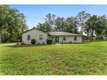 Charming single-story home with a well-maintained lawn and classic green trim at 12681 Se 54Th Ave, Belleview, FL 34420