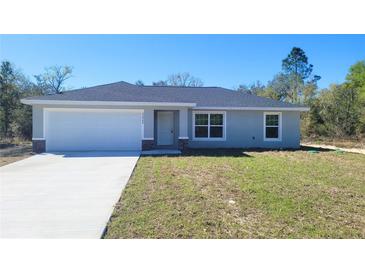 Charming single-story home with a well-manicured lawn and attached two-car garage at 20154 Sw Rainbow Lakes Blvd, Dunnellon, FL 34431