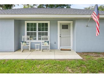 Cozy front porch with rocking chairs, perfect for relaxing and enjoying the outdoors at 2924 Se 142Nd Pl, Summerfield, FL 34491