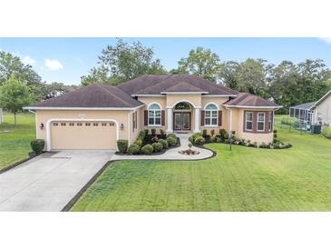 Charming single-story home with a well-manicured lawn and a classic stucco facade at 5024 Sw 114Th Street Rd, Ocala, FL 34476