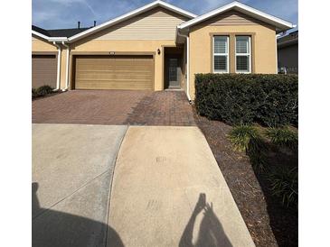 Charming home featuring a brick driveway, a two-car garage, and manicured landscaping at 5235 Nw 33Rd Pl, Ocala, FL 34482