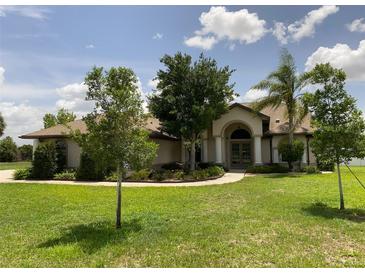 Beautiful home with a well-manicured lawn and inviting entryway with classic architectural columns at 9923 Se 64Th Ave, Belleview, FL 34420