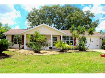 Charming single-story home featuring a well-manicured lawn and nicely landscaped front yard at 8896 Sw 116Th Place Rd, Ocala, FL 34481