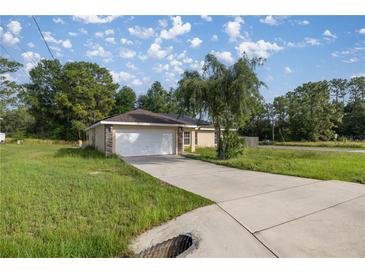 Charming single-Gathering home with a spacious driveway and a well-maintained front lawn and attached two-car garage at 51 Pine Trace Loop, Ocala, FL 34472