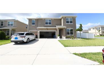 Two-story home featuring an attached two-car garage, manicured lawn, and a concrete driveway at 5962 Sw 80Th Ln, Ocala, FL 34476