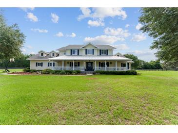 Expansive two-story home with a welcoming front porch and ample lawn space at 9095 Sw 9Th Ter, Ocala, FL 34476