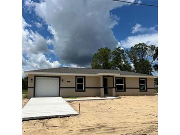 New construction shows a single story home with an attached garage and a modern design at 10401 Se 125Th Ln, Belleview, FL 34420