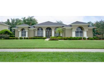 Charming one-story home featuring a large, well-manicured front lawn and beautiful, mature landscaping at 17034 Florence View Dr, Montverde, FL 34756