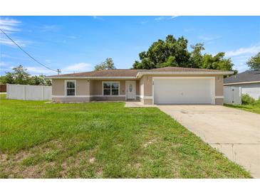Charming single-story home with a well-maintained lawn and attached two-car garage at 28 Hemlock Radial Loop, Ocala, FL 34472