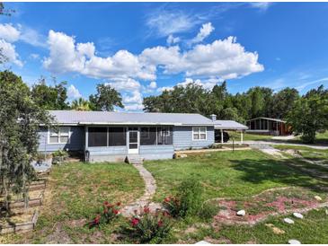 Charming single-story home with a cozy screened-in porch and lush front yard landscaping at 4501 Detour Rd, Haines City, FL 33844
