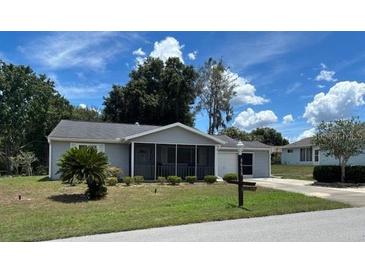 Charming single-story home featuring a screened-in porch, well-manicured lawn, and attached garage at 8650 Sw 108Th Pl, Ocala, FL 34481