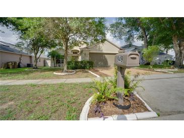 Charming single-story home features a well-manicured lawn, mature trees, and a cozy mailbox area at 949 Woodsong Way, Clermont, FL 34714