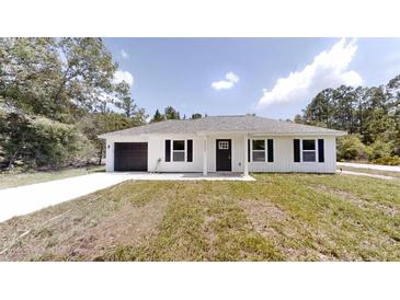 Charming single-story home featuring a well-manicured lawn, a covered front porch, and an attached one-car garage at 2264 Sw Moines Ct, Dunnellon, FL 34431