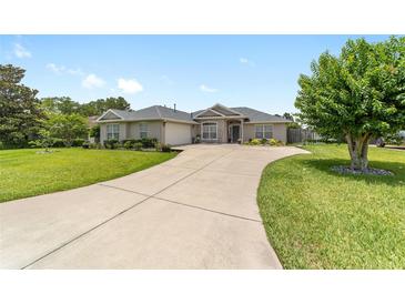 Charming single story home with a large driveway and well-manicured lawn and mature landscaping at 2413 Se 23Rd St, Ocala, FL 34471