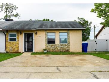 Charming single-story home with stone accents, a well-maintained front yard, and a concrete driveway at 2563 Coral Ave, Kissimmee, FL 34741