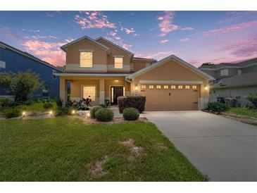 Inviting two-story home featuring manicured lawn, tidy shrubbery, and neutral stucco exterior with an attached two car garage at 4094 Sw 51St Ct, Ocala, FL 34474
