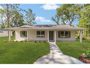 Charming single-story home with a well-manicured lawn and inviting walkway at 5400 Nw 9Th St, Ocala, FL 34482