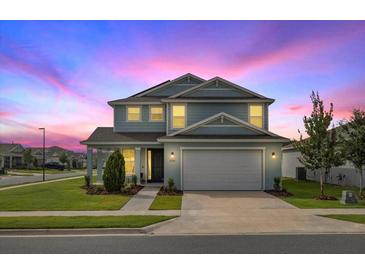 Charming two-story home with a well-manicured lawn and a two-car garage in a suburban neighborhood at 7695 Sw 64Th Street Rd, Ocala, FL 34474