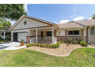 Charming single-story home with a cozy front porch and well-manicured landscaping at 8881 Sw 94Th St # E, Ocala, FL 34481