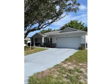 Cozy single-story home featuring an attached two-car garage and a well-manicured front yard at 9711 Sw 97Th Pl, Ocala, FL 34481