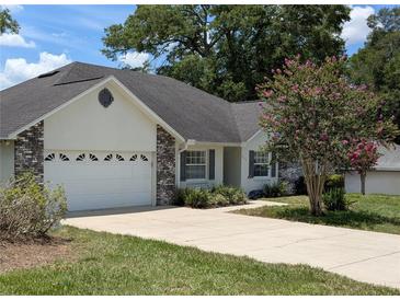 Charming single-story home with a two-car garage and a well-maintained front yard with mature landscaping at 3650 Se 55Th Ct, Ocala, FL 34480