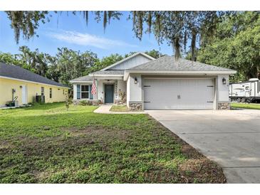 Charming single-story home with a two-car garage, green lawn, and inviting curb appeal at 710 Barwick St, Wildwood, FL 34785