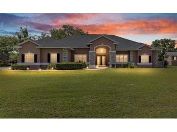Spacious front yard featuring a well-maintained lawn and a beautiful one-story home with stone accents at 7220 Nw 83 Ter, Ocala, FL 34482