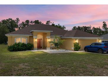Charming single-story home with a well-maintained lawn and a two-car garage, with updated landscaping at 9562 Sw 45Th Ave, Ocala, FL 34476