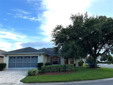 Charming single-story home features a well-manicured lawn, mature tree and a convenient two-car garage at 9706 Sw 92Nd Place Rd, Ocala, FL 34481