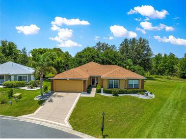 Charming one-story home with manicured lawn, mature trees, and well maintained landscape at 13835 Se 85Th Cir, Summerfield, FL 34491