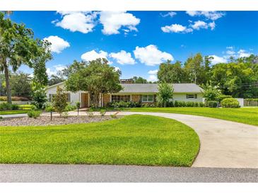 Beautifully landscaped yard with a winding driveway leading to a charming single-story home at 1922 Se 13Th St, Ocala, FL 34471