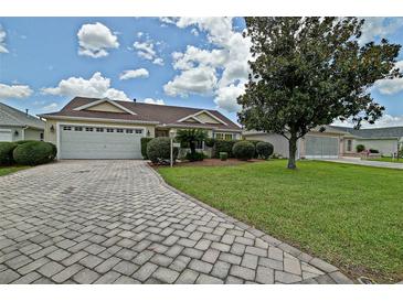 Charming single-story home with a well-manicured lawn and a brick driveway at 3146 Williams Rd, The Villages, FL 32162