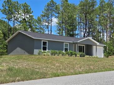 Beautiful one-story home with manicured landscaping and an attached one-car garage at 5185 Sw 158Th Pl, Ocala, FL 34473