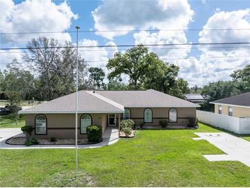 Charming single-story home with a well-manicured lawn and lovely landscaping at 5347 Pecan Rd, Ocala, FL 34472